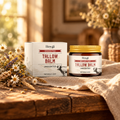 Hoygi Tallow Balm on a rustic wooden table with dried wildflowers